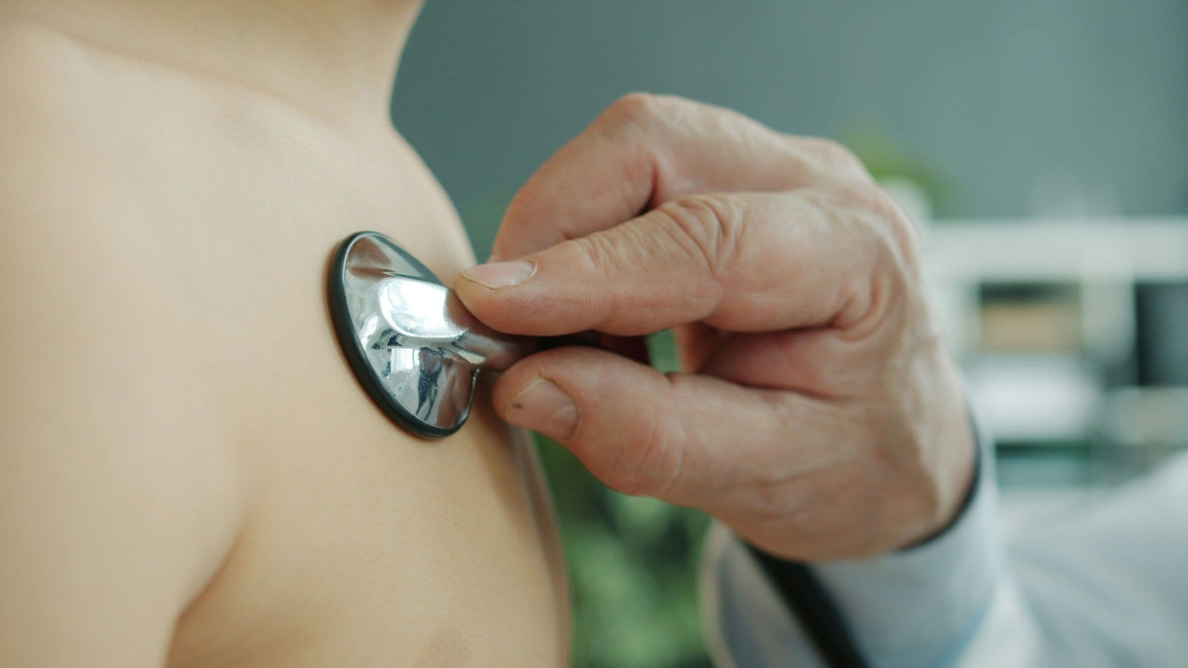 Médico auscultando a un paciente con estetoscopio
